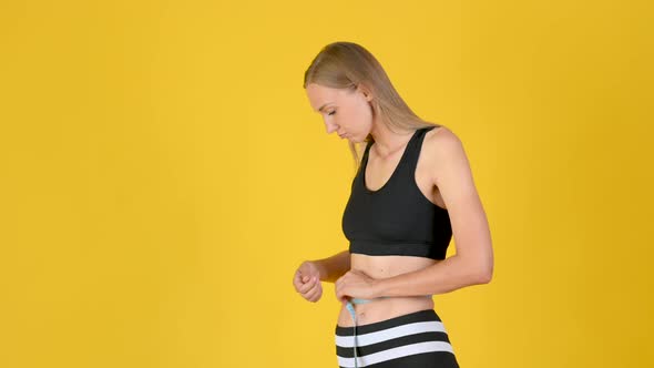 Young Beautiful Girl Measures Her Waist With A Measuring Tape