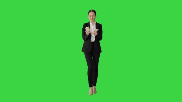 Happy Business Woman Counting Money While Walking on a Green Screen, Chroma Key.