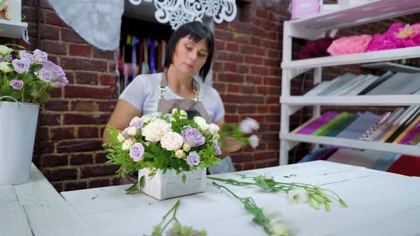 Professional Florist Composes Flower Arrangement in Wooden Box