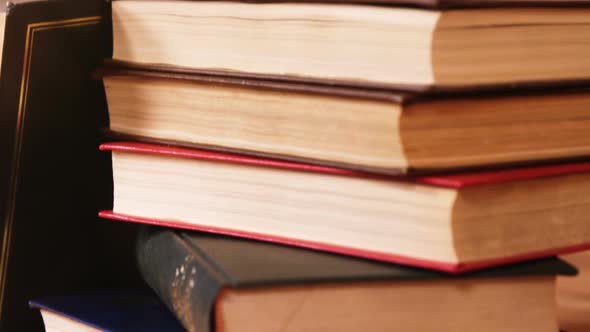 Stack of books with spectacles on a desk