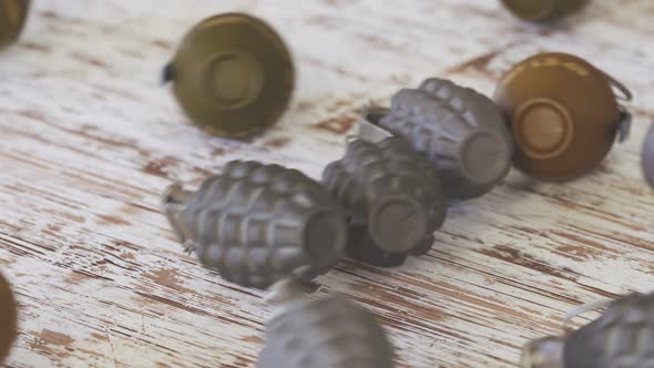 Three types of grenades rolling on a wooden surface. Explosives throw.