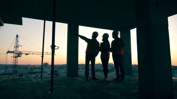 Multistory House in Progress with a Group of Engineers Talking in It During Sunset alt