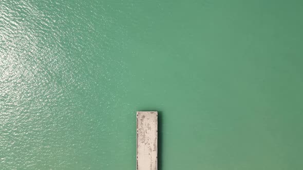 Sea with a Concrete Long Pier in the Spring with People Filmed on a Drone