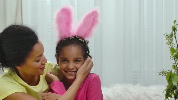 Mom and Daughter with Funny Bunny Ears Happily Hugging and Smile