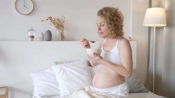 Pregnant Female Having Corn Flake Cereals For Breakfast. Pregnancy And Good Morning Concept.
