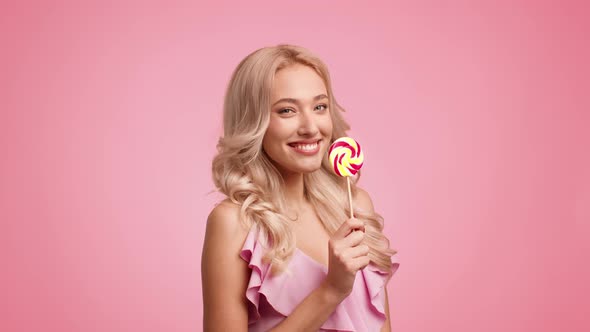 Woman Posing Eating Lollipop Kissing Candy Winking Eye Pink Background