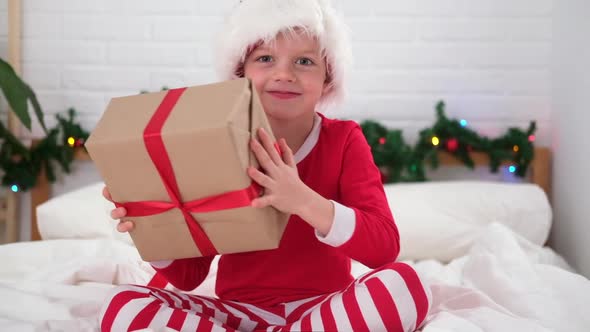 Little Boy Shakes Gift Box to Find Out What is Inside