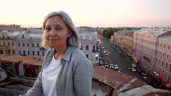 Portrait of Aged Woman on Roof in Downtown