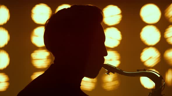 Silhouette Guy Blowing Saxophone on Stage Closeup