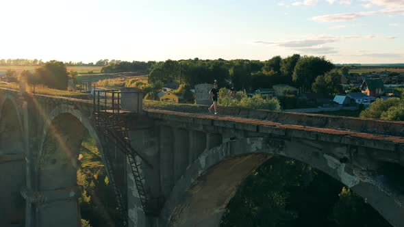 Deserted Bridge and a Male Athlete Jogging Along It