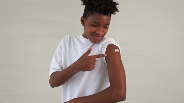 African American Teenager Showing COVID19 Vaccine Bandage Merrily