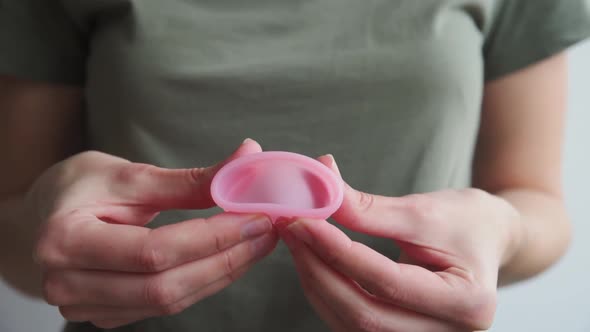 Woman Holds Menstrual Cup in Hands