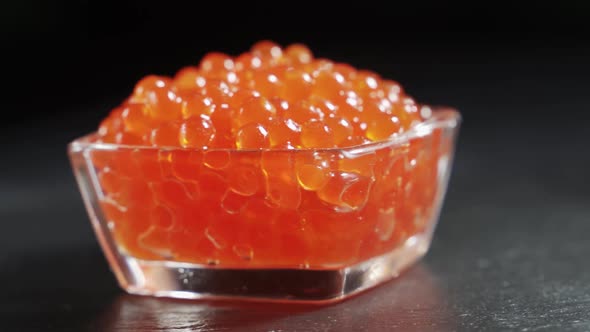 Red Caviar Rotated Over Black Background. Close-up Salmon Caviar Rotation.