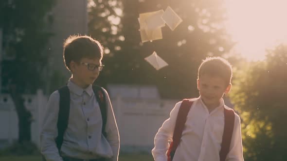 Schoolboys Throw Books and Give Five in Park Slow Motion