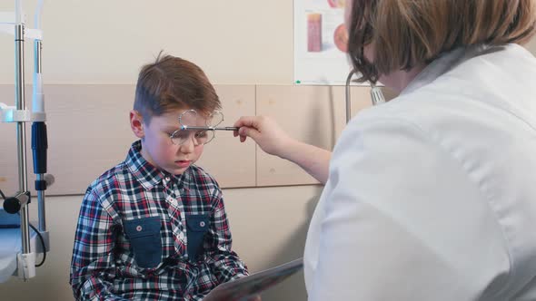 Ophthalmologist Treatment - Woman Doctor About To Check the Eyes of a Little Boy