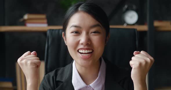 Excited Asian Businesswoman Looking at Camera Showing Yes Gesture Indoors at Home Office