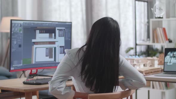 Asian Woman Engineer Having A Backache While Designing House On A Desktop At Home