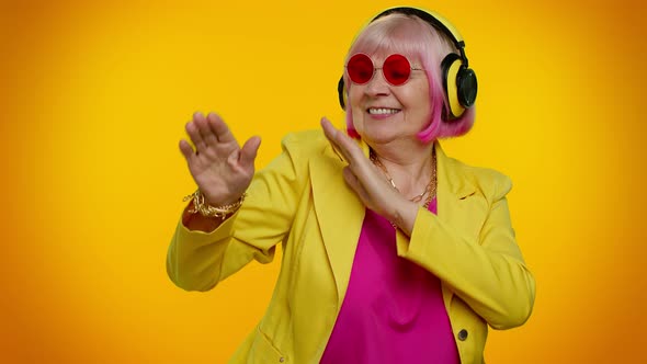 Senior Woman Listening Music on Headphones Dancing Disco Fooling Having Fun Gesticulating Hands