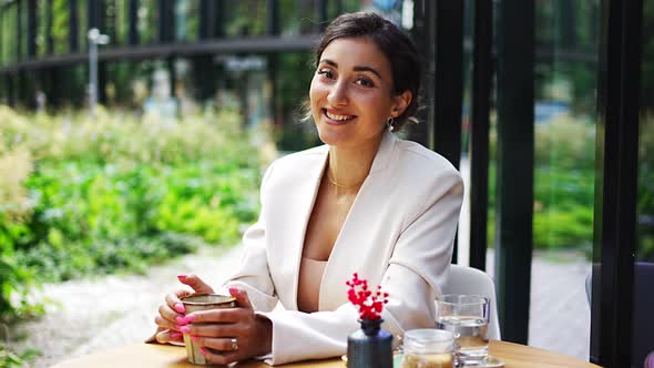 Young Business Woman Smiling in Street Cafe in City