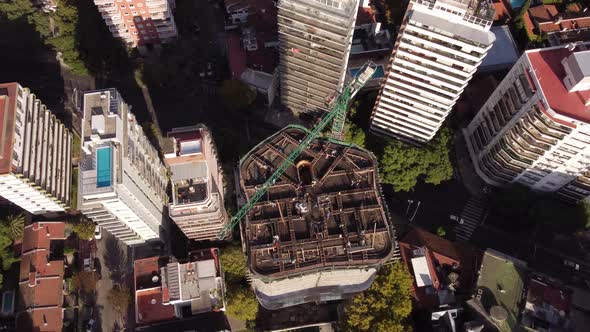 Aerial drone top view over skyscraper construction site with crane in downtown of Buenos Aires