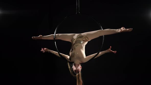 Wide Shot Slim Young Woman Performing Tricks on Air Hoop Hanging at Black Background