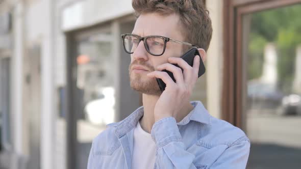 Casual Young Man Talking on Phone While Standing Outdoor