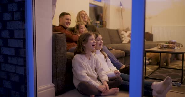 Happy family at home sitting on the sofa and watching tv