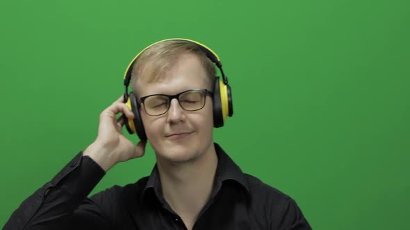 Guy Listens To Music in Wireless Yellow Headphones and Dances, Chroma Key