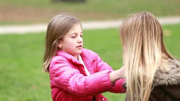 Little girl putting her hands through her mother's hair