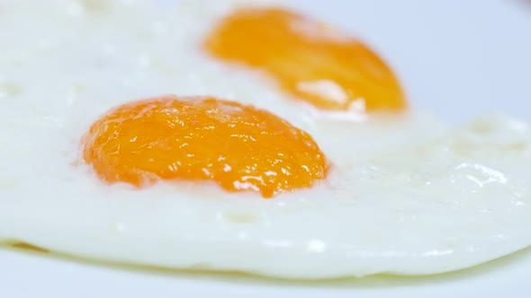 Fried on oil chicken egg yolks served slow tilt 4K 2160p 30fps UltraHD video - Tasty hen eggs fried 