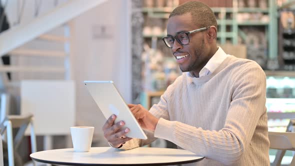 Serious Professional African Man Using Tablet in Cafe 