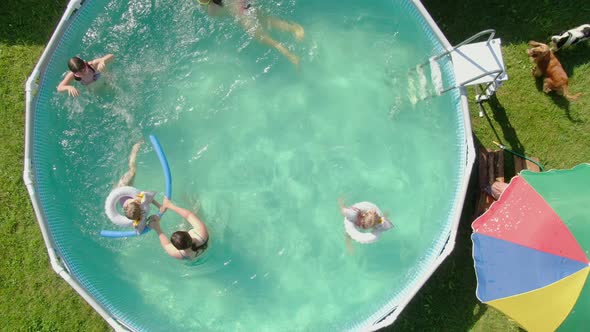 Aerial Shooting of Children Swimming in the Blue Round Swimming Pool
