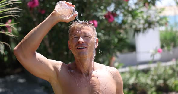 Handsome Man Douses Himself with Cold Water From Bottle in Summer