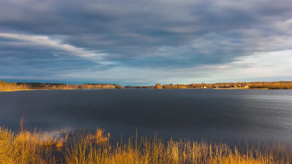 Stormy clouds over lake surrounded by yellow autumn forest