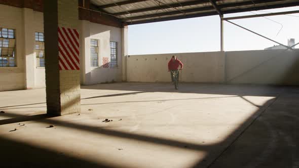 BMX rider in an empty warehouse