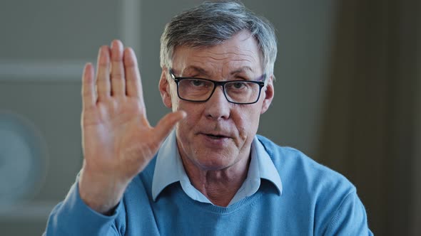 Serious Old Senior Mature 60s Man Stretch Out Palm to Camera Says Stop Gesture Indoors