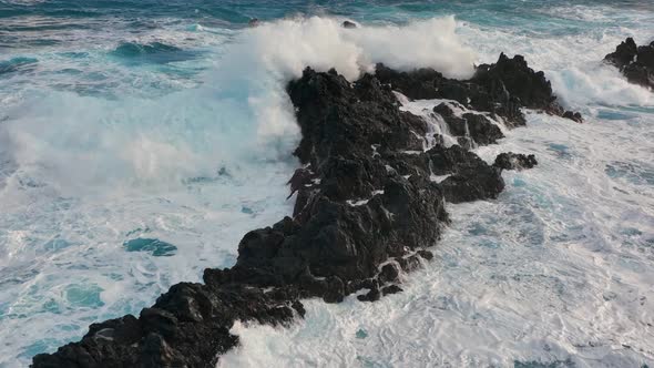 Slow Motion Aerial Shot of Powerful Wave Crashing on Rocks