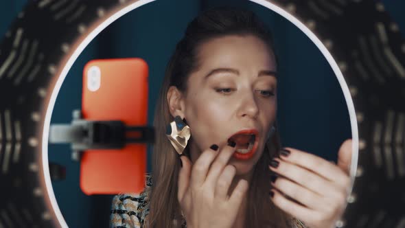 Confident Nice Woman Video Blogger Applies Lipstick in Front of Ring Light