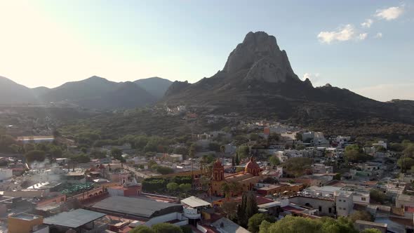 Picturesque Town Of Bernal, Queretaro With The Peña de Bernal Monolith In The Background - aerial dr