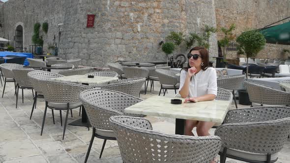 The Girl is Sitting at a Table in a Restaurant