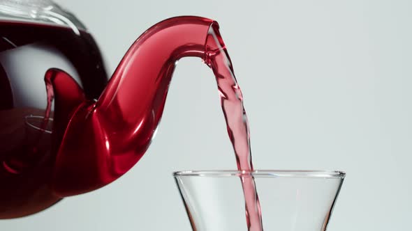 Pouring Red Fruit Tea on White Background