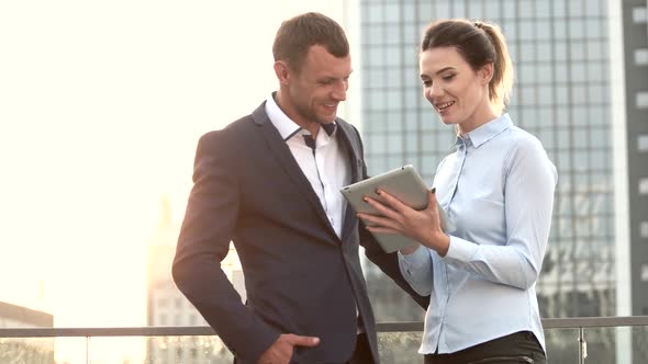 Businessman and Woman Holding Tablet