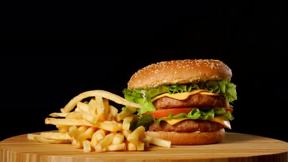 Craft Beef Burger and French Fries on Wooden Table Isolated on Black Background.