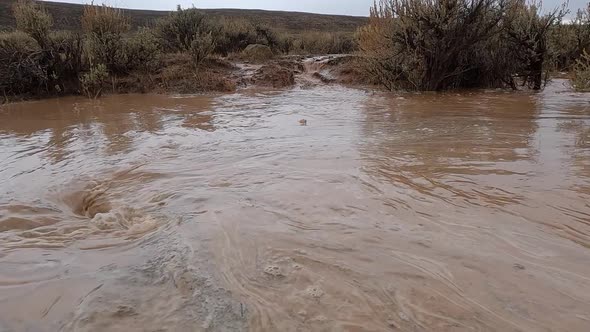 Panning over flood water being suctioned into whirlpool after rain storm