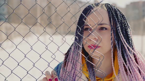 Stylish Woman Leaning on Metal Fence