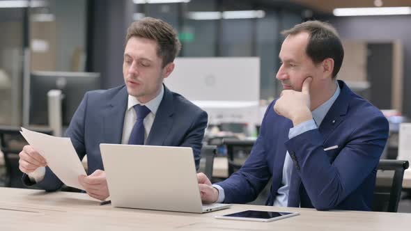 Businessman Working with Colleague in Office