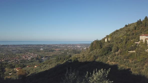 Drone Aerial Shot rising above the beautiful Tuscan Hills revealing Town of Lido di Camaiore