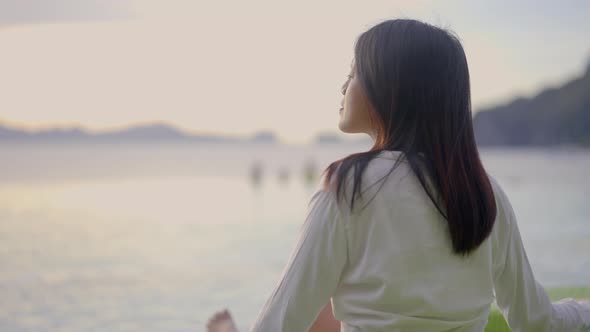 Woman Enjoys the View of Coming Sunset in Front of an Infinity Swimming Pool