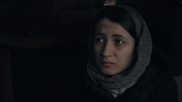 Woman Sits in the Basement During Shelling