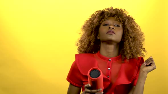 Girl of African American Woman Holding a Player and Dancing .Yellow Background